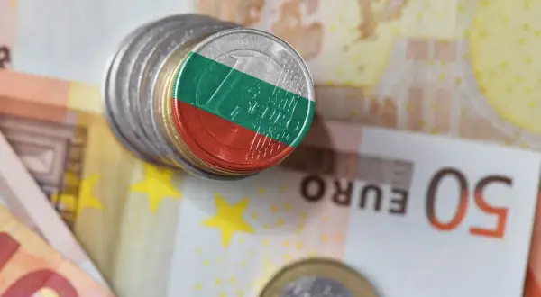 Monety z flagą Bułgarii, symbolizujące lew bułgarski, leżą na banknotach euro.