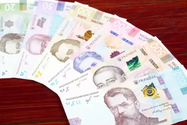 Ukraińska waluta, hrywny, ułożone wachlarzowo na drewnianym tle. Widoczne nominały 20, 50, 100, 200, 500 i 1000.
